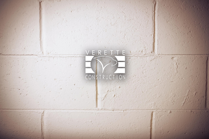 verette construction logo against brick wall